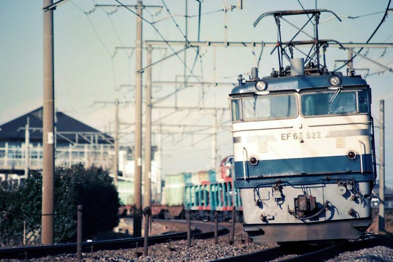 ク5000形車運車を連結したEF65形牽引の貨物列車（1988年、新白岡～白岡間で恵 知仁撮影）